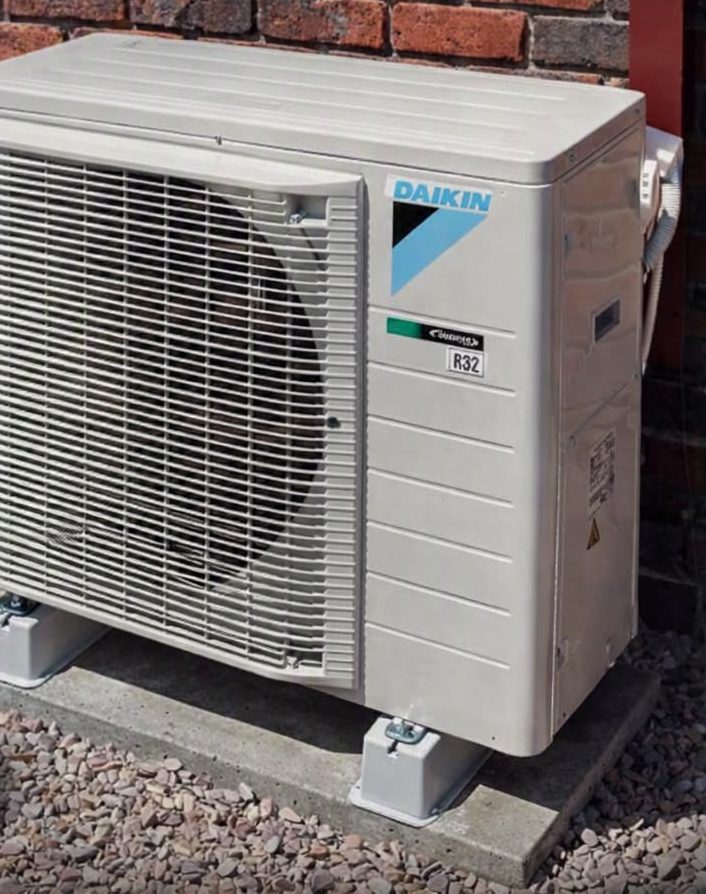 Air source heat pump outside a brick home